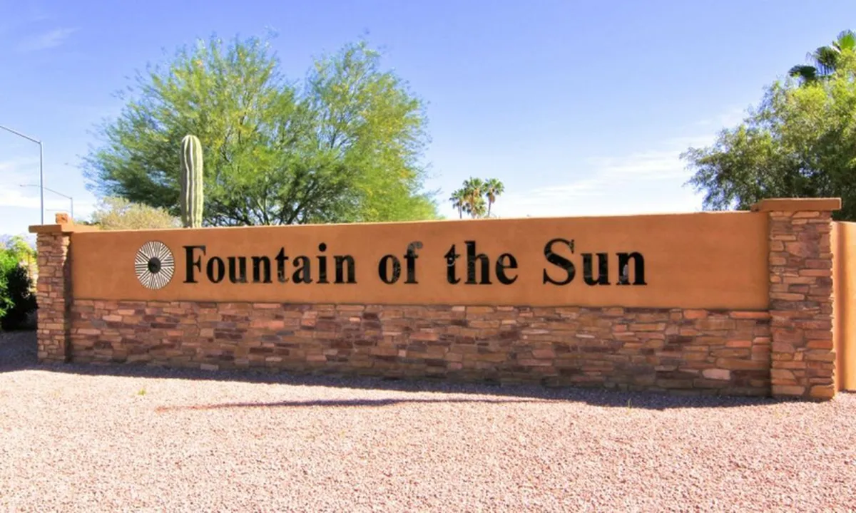 This exterior scene highlights the attractive community signage, appealing landscaping, and desert-style cactus plantings. The setting is designed for gatherings, with open space that hints at both community spirit and opportunities for outdoor leisure or events.