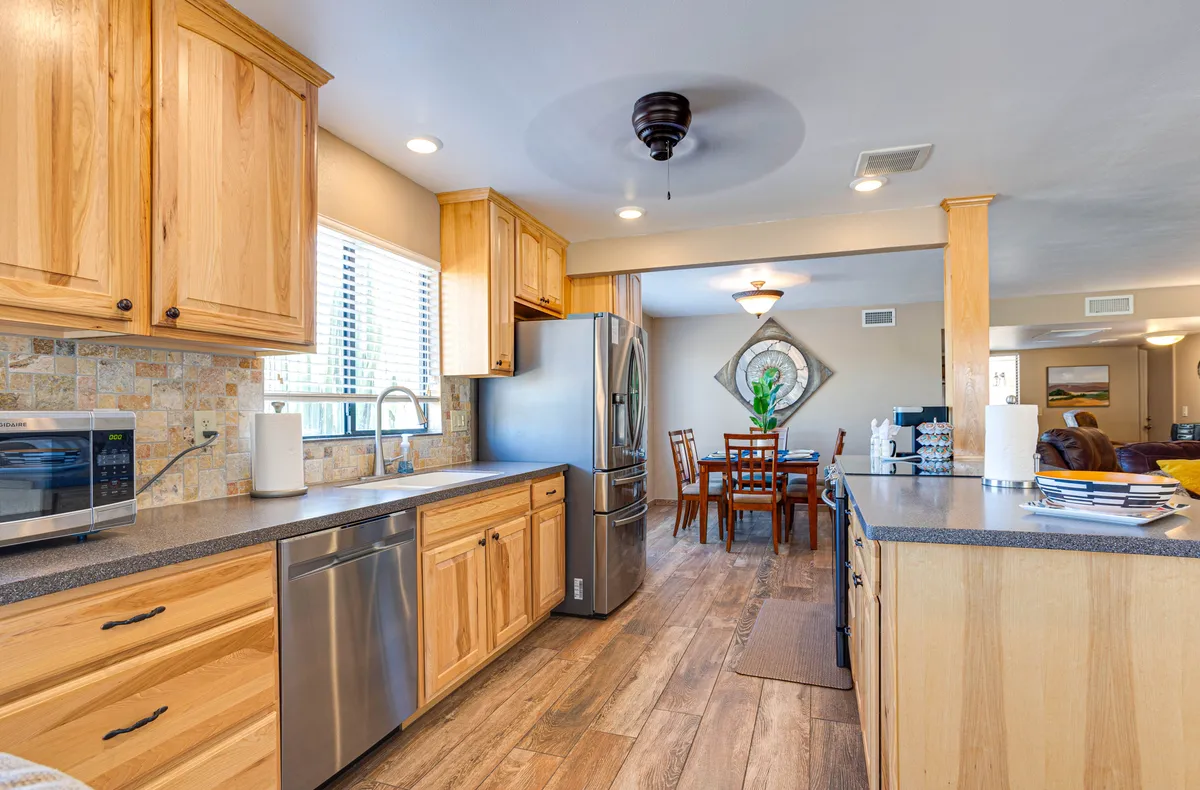 This inviting kitchen scene features a large island, sleek stainless steel appliances, and an adjoining dining table. The setup is ideal for both everyday cooking and hosting celebratory meals, with ample space for family or group gatherings.